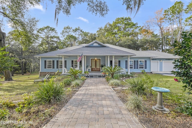 view of front of house with a garage, a front lawn, and a porch