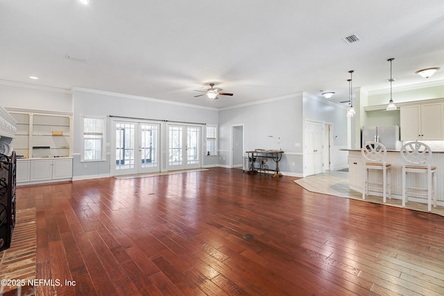 unfurnished living room with wood-type flooring, crown molding, and ceiling fan