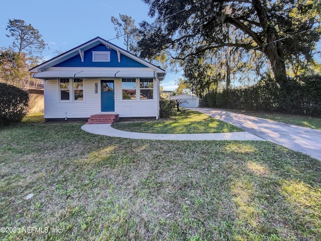 view of front of property with an outbuilding, a garage, and a front yard