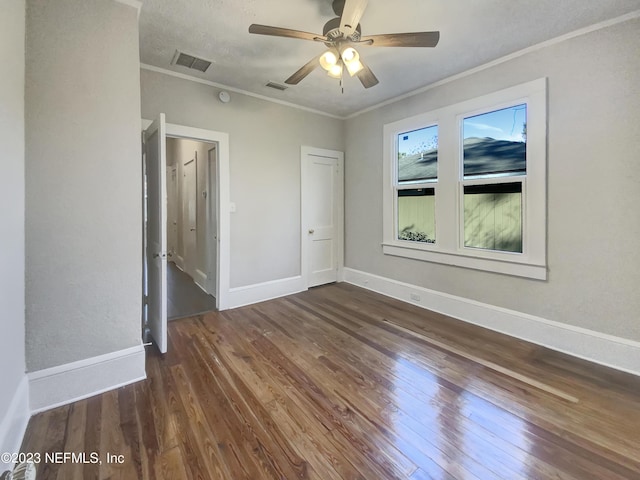 unfurnished bedroom featuring ceiling fan, dark hardwood / wood-style flooring, and crown molding