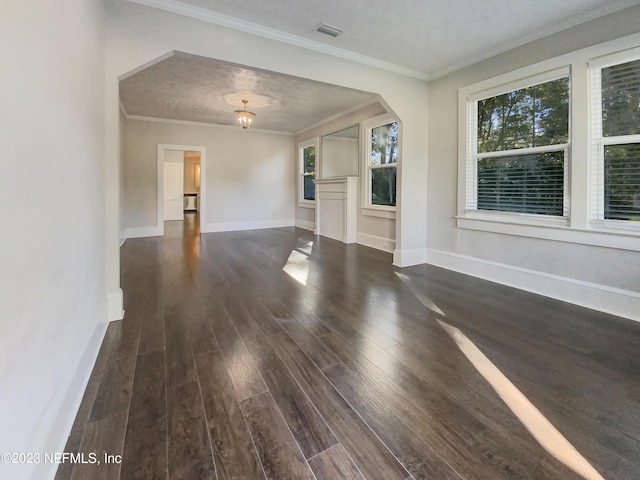 unfurnished living room with a textured ceiling, crown molding, and dark wood-type flooring