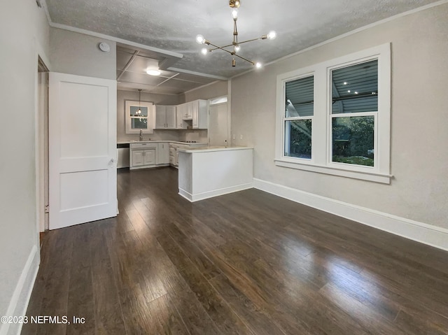 kitchen with white cabinets, stainless steel dishwasher, dark hardwood / wood-style floors, a notable chandelier, and kitchen peninsula