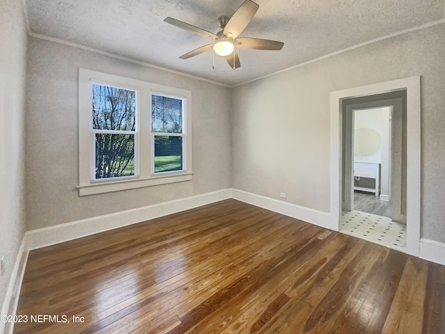 spare room featuring wood-type flooring, a textured ceiling, ceiling fan, and crown molding