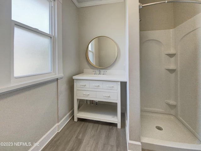 bathroom with hardwood / wood-style floors, a shower, ornamental molding, and a wealth of natural light