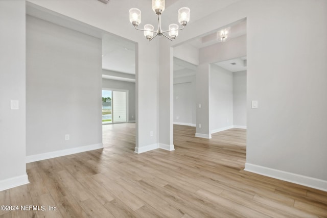 unfurnished dining area featuring a notable chandelier and light hardwood / wood-style flooring