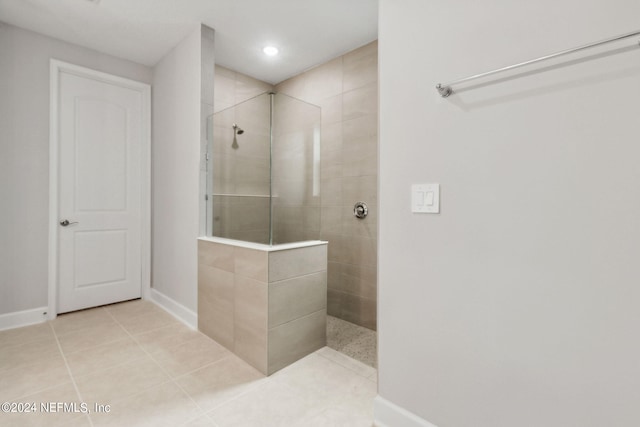 bathroom featuring tile patterned flooring and a tile shower