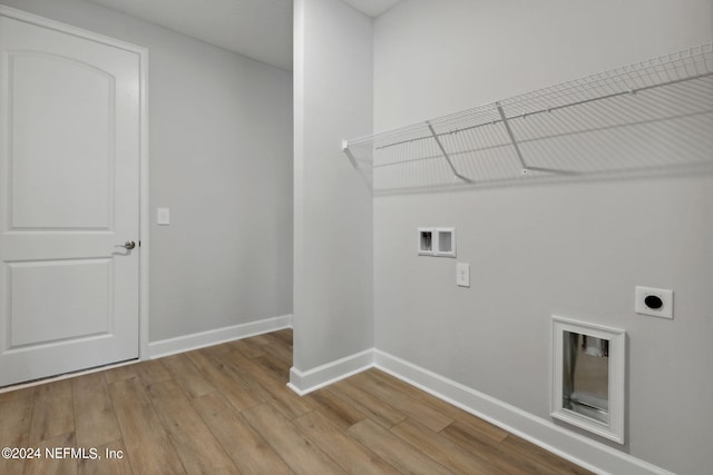 washroom featuring electric dryer hookup, hookup for a washing machine, and light hardwood / wood-style flooring