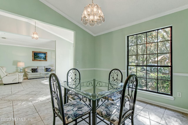 dining room featuring a chandelier, crown molding, vaulted ceiling, and baseboards