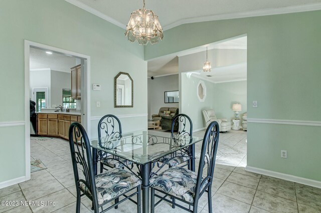 dining space with an inviting chandelier, vaulted ceiling, crown molding, and light tile patterned flooring