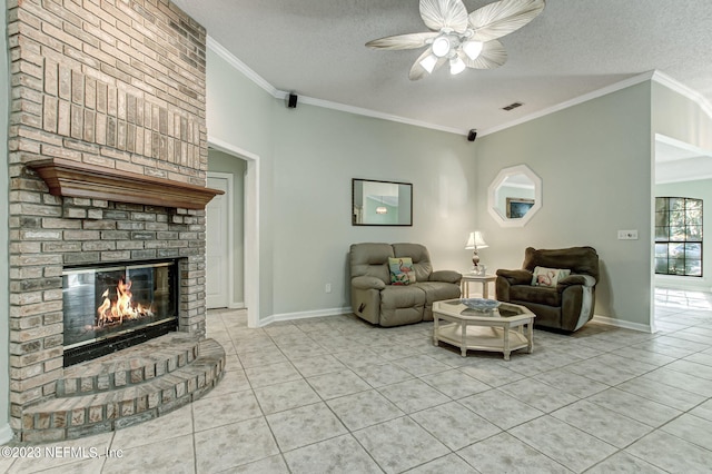 living area with visible vents, tile patterned floors, a textured ceiling, crown molding, and a brick fireplace