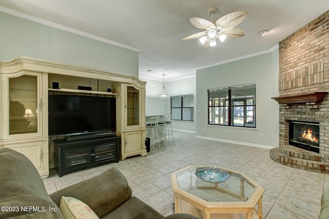 living room featuring ornamental molding, light tile patterned flooring, a fireplace, and a ceiling fan