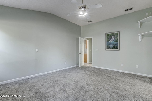 empty room with visible vents, carpet flooring, vaulted ceiling, ceiling fan, and baseboards