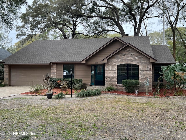 view of front of house with a garage, brick siding, a shingled roof, and driveway