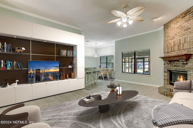 tiled living room featuring a brick fireplace, baseboards, ornamental molding, and a ceiling fan