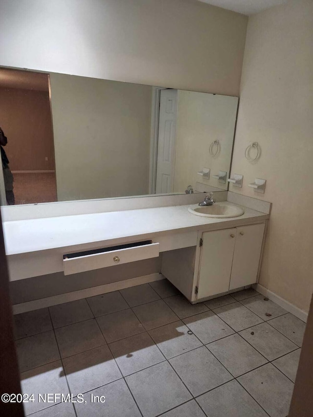 bathroom with vanity, baseboards, and tile patterned floors