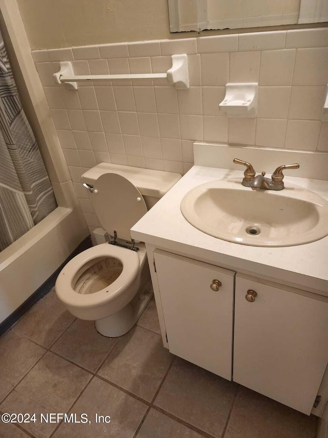 full bathroom with toilet, tile patterned flooring, tile walls, and vanity