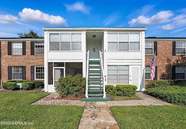 4358 Timuquana Rd Unit 205, Jacksonville, FL 32210 - view of front of property featuring stairway, a front yard, brick siding, and central AC