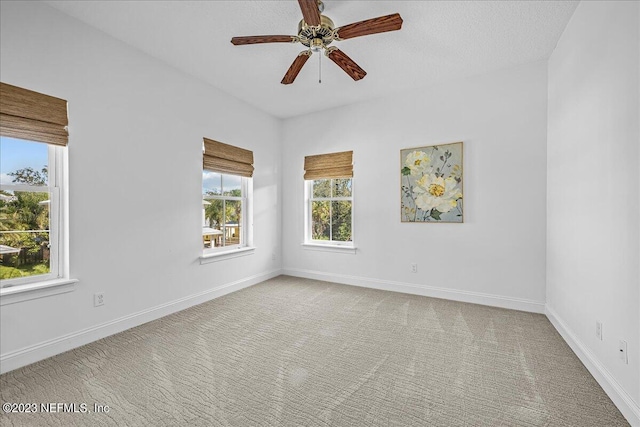 carpeted spare room with ceiling fan