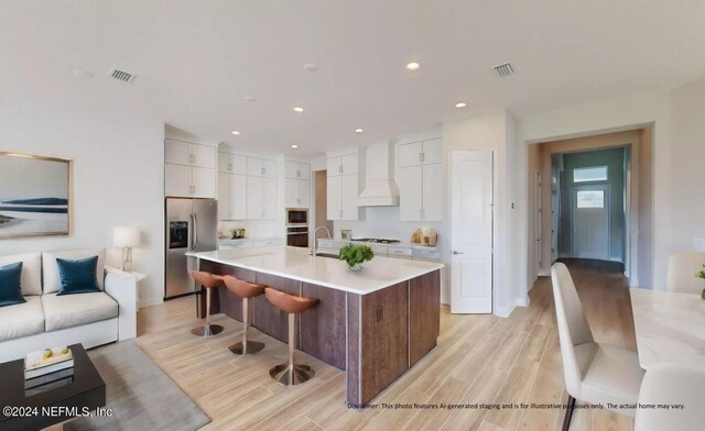 kitchen with appliances with stainless steel finishes, white cabinets, custom range hood, and visible vents