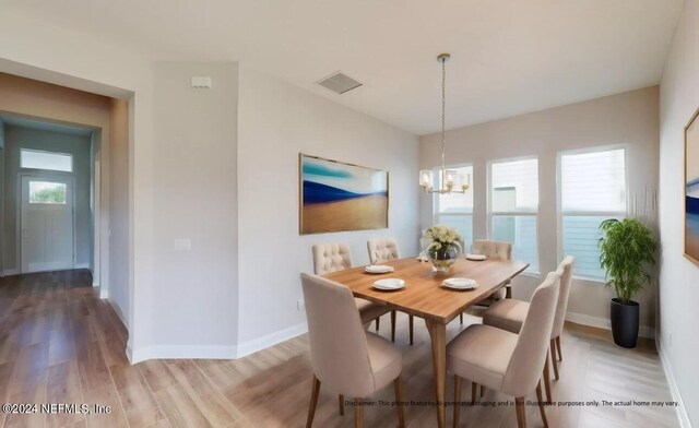 dining space featuring a chandelier, light wood-type flooring, visible vents, and baseboards