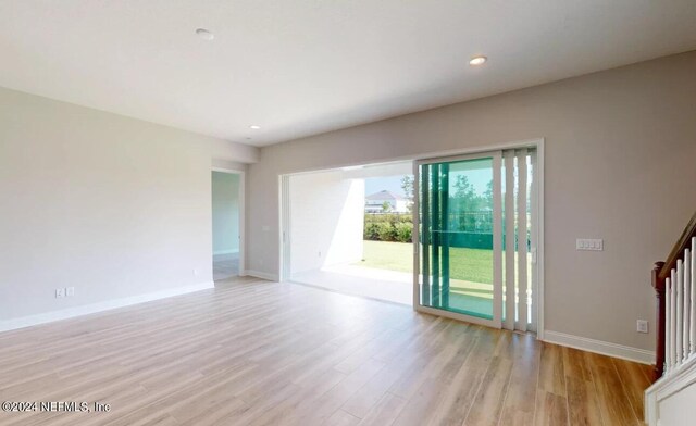 interior space featuring light wood finished floors, stairs, baseboards, and recessed lighting