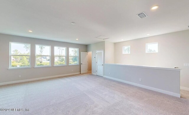 empty room featuring light carpet, recessed lighting, visible vents, and baseboards