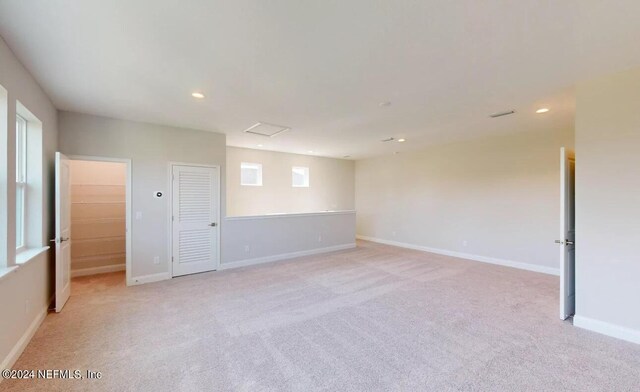 unfurnished room with light carpet, recessed lighting, and baseboards