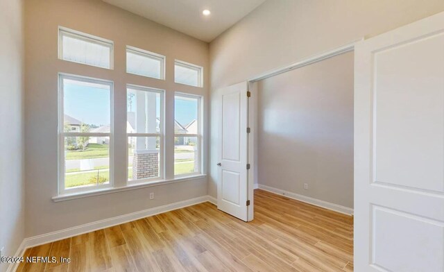 empty room with recessed lighting, light wood-type flooring, and baseboards