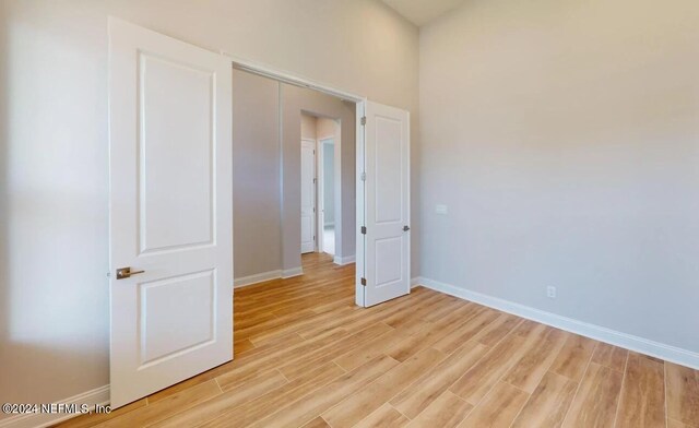 unfurnished bedroom with light wood-style flooring and baseboards