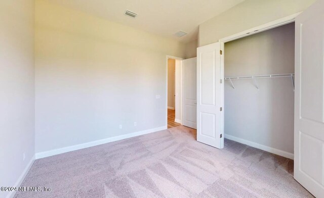 unfurnished bedroom featuring carpet, visible vents, and baseboards