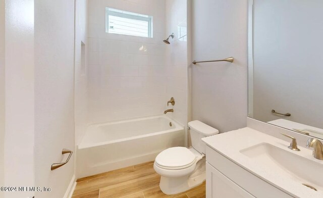 full bath featuring vanity, bathing tub / shower combination, wood finished floors, and toilet