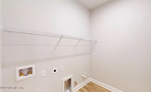 clothes washing area with laundry area, hookup for a gas dryer, hookup for an electric dryer, light wood-type flooring, and washer hookup