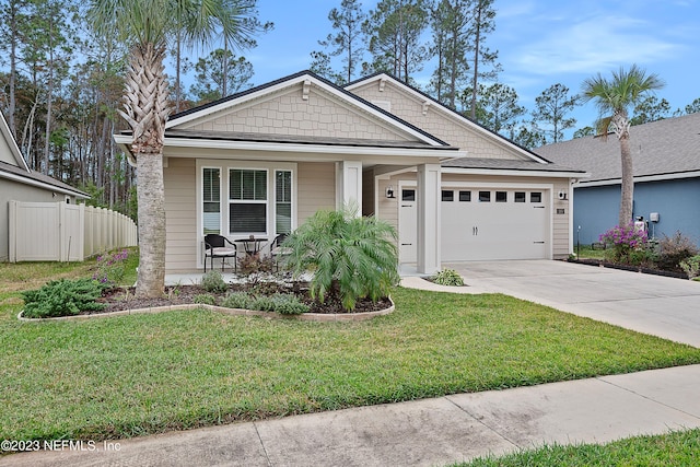 view of front of home with a garage, covered porch, and a front lawn