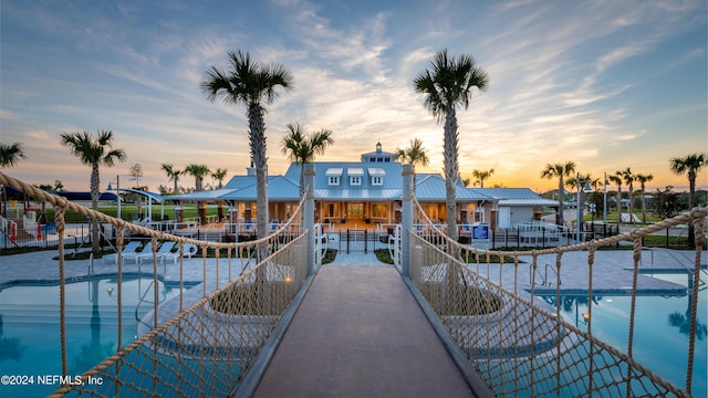 view of dock featuring a community pool and a patio area