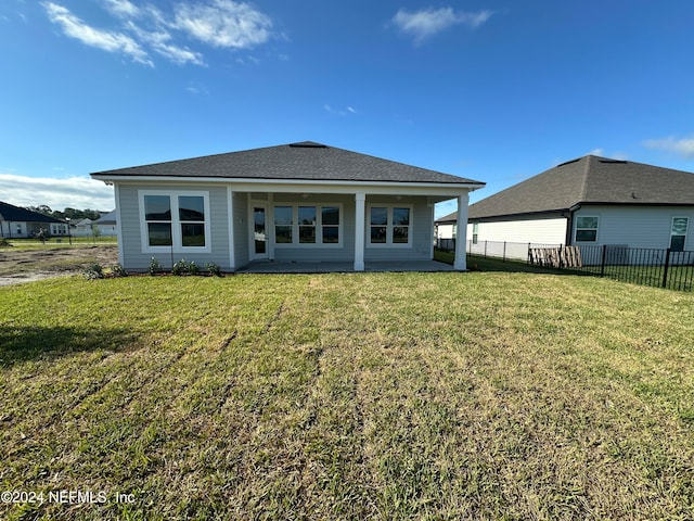 rear view of house with a patio area and a lawn