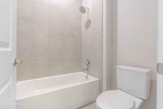 bathroom featuring tiled shower / bath and toilet