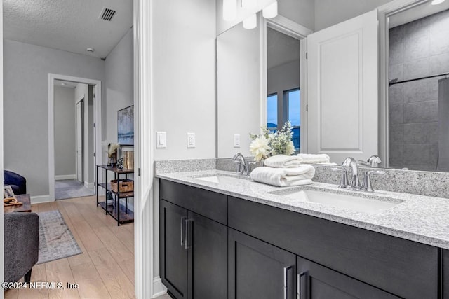 bathroom featuring vanity, hardwood / wood-style floors, and a textured ceiling