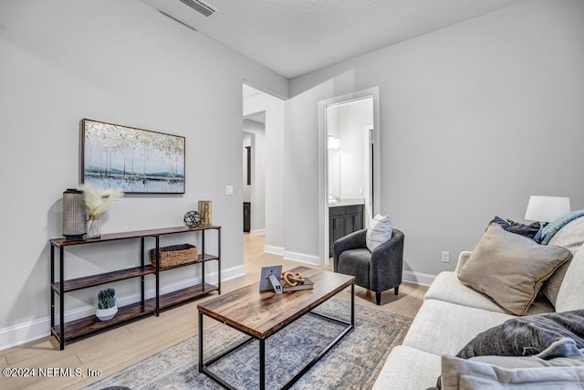 living room with light hardwood / wood-style flooring and a textured ceiling