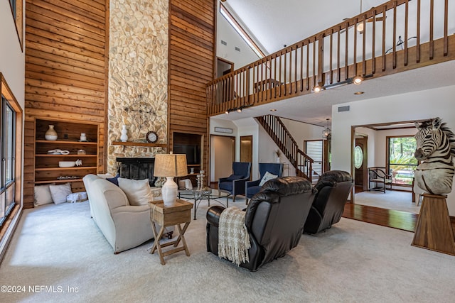 carpeted living room featuring built in features, a fireplace, and a towering ceiling