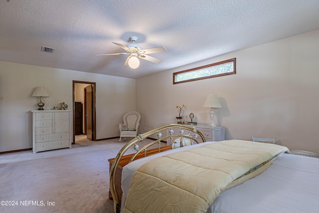 carpeted bedroom featuring a textured ceiling and ceiling fan