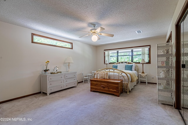 carpeted bedroom with ceiling fan and a textured ceiling