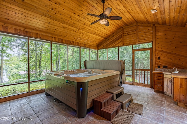 sunroom / solarium with lofted ceiling, ceiling fan, a hot tub, and wood ceiling