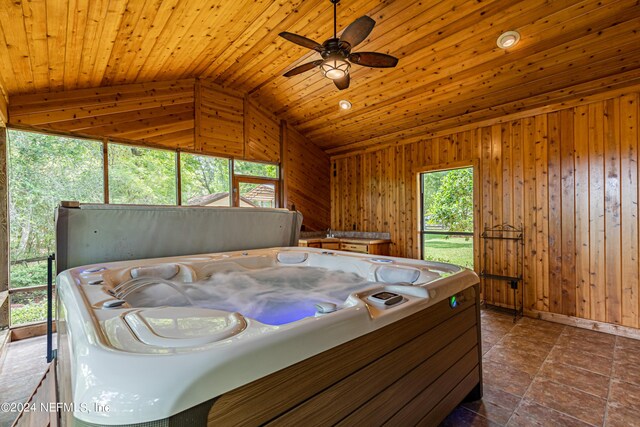 bedroom with vaulted ceiling, wood walls, and wooden ceiling