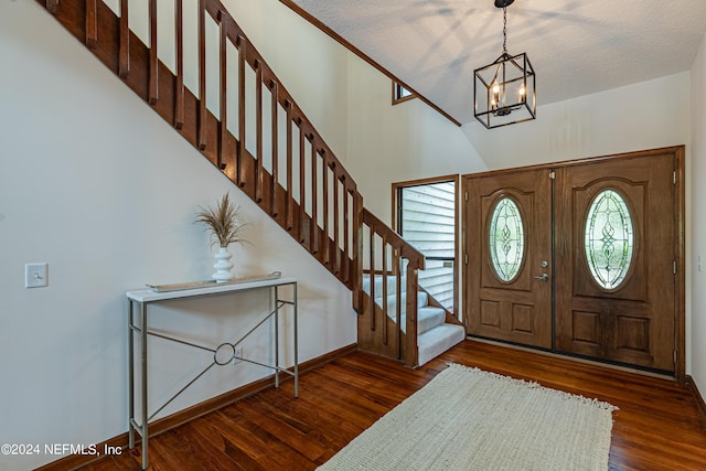 entryway with french doors, dark hardwood / wood-style flooring, a textured ceiling, and a notable chandelier