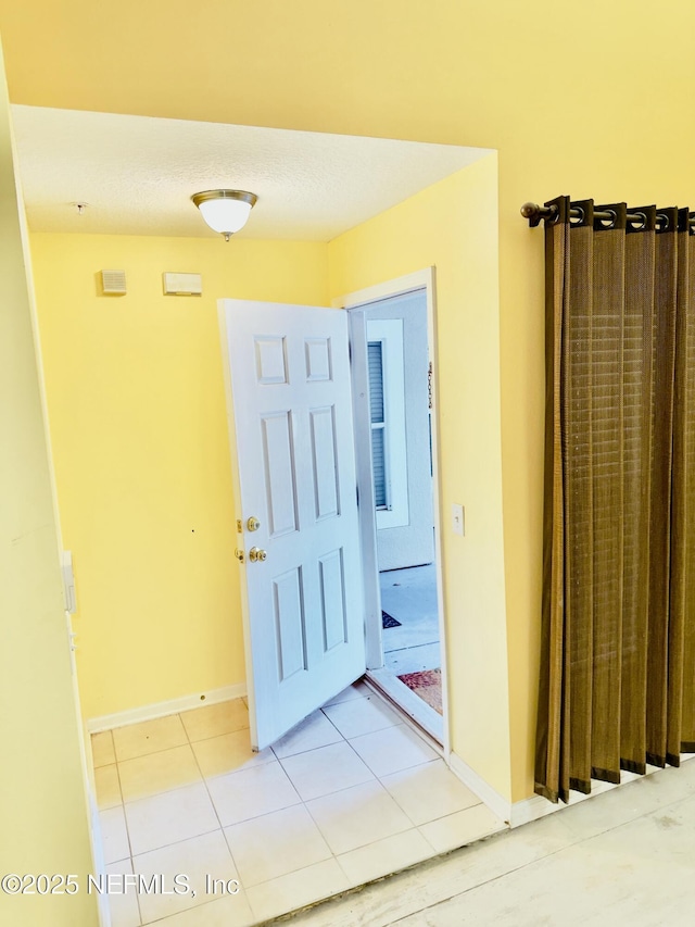 corridor featuring light tile patterned floors