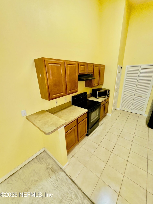 kitchen featuring light tile patterned floors and black electric range oven