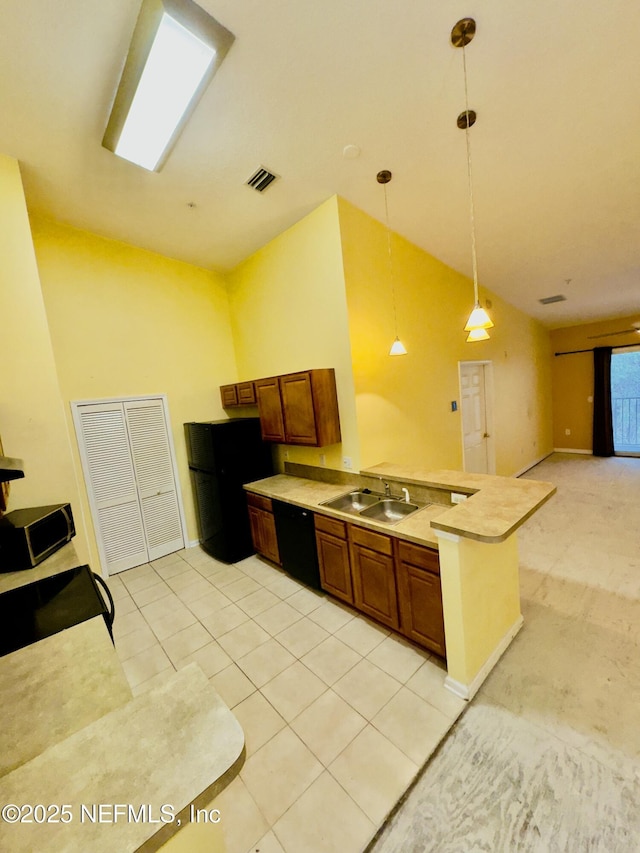 kitchen featuring light tile patterned flooring, pendant lighting, black appliances, and sink