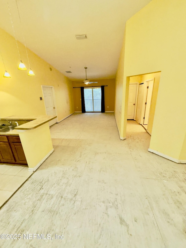 unfurnished living room featuring ceiling fan, vaulted ceiling, and sink