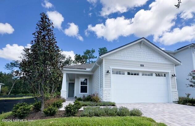 view of front of home with a garage and decorative driveway