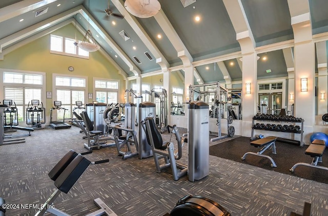 exercise room featuring visible vents, a wealth of natural light, and high vaulted ceiling